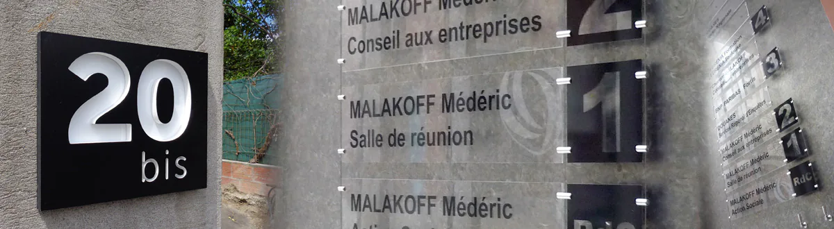 Plaque de rue en relief pour identifier le numéro d'une propriété- Plaques plexiglass nominatives avec lettrage noir brillant montées sur cables métalliques pour lister et orienter les visiteurs dans le hall d'un bâtiment public.